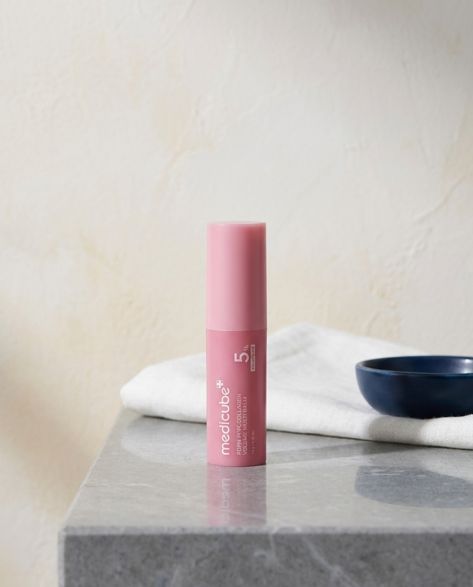 Medicube PDRN Balm Stick styled on a stone ledge with linen and navy ceramic dish